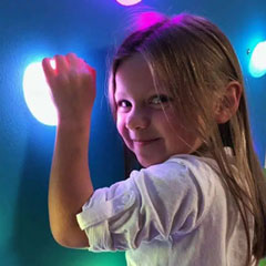 Young girl on GlowHolds interactive climbing wall